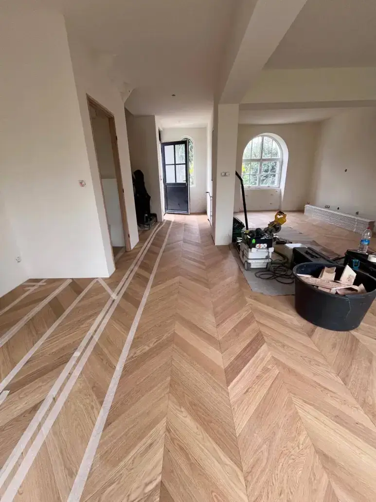 Salon de style haussmannien en cours de rénovation avec un parquet en bâton rompu
