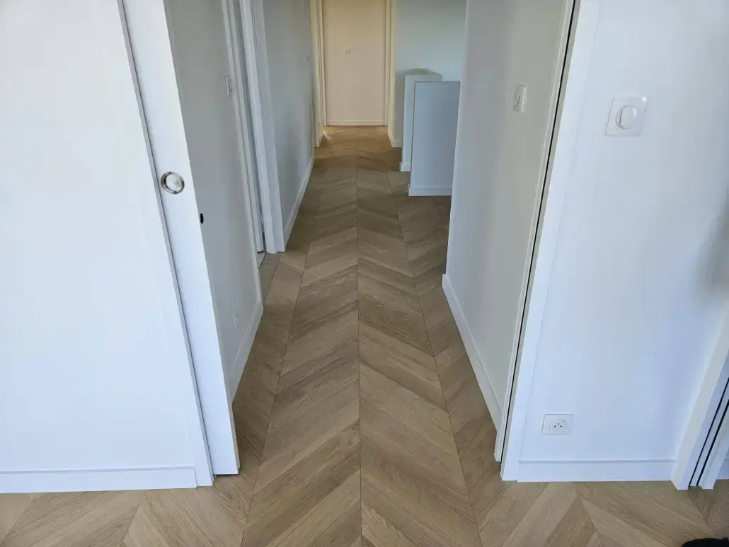 Couloir lumineux mettant en valeur un parquet pose en point de Hongrie