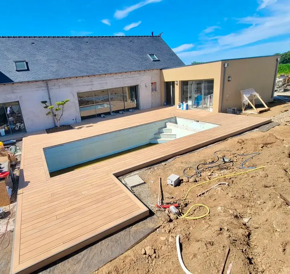 Vue générale d'une plage de piscine en terrasse bois composite à Planguenoual