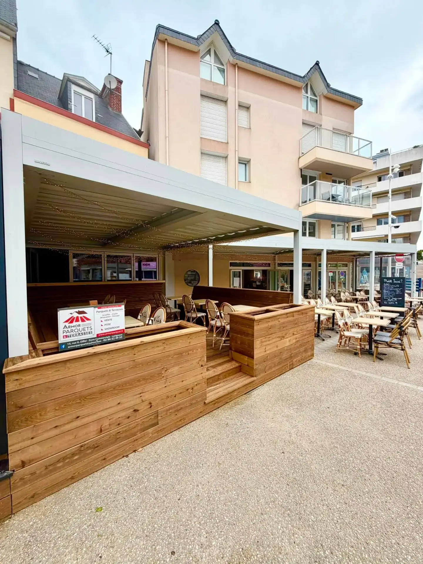 Vue latérale de la terrasse en pin scandinave du restaurant Les Bains
