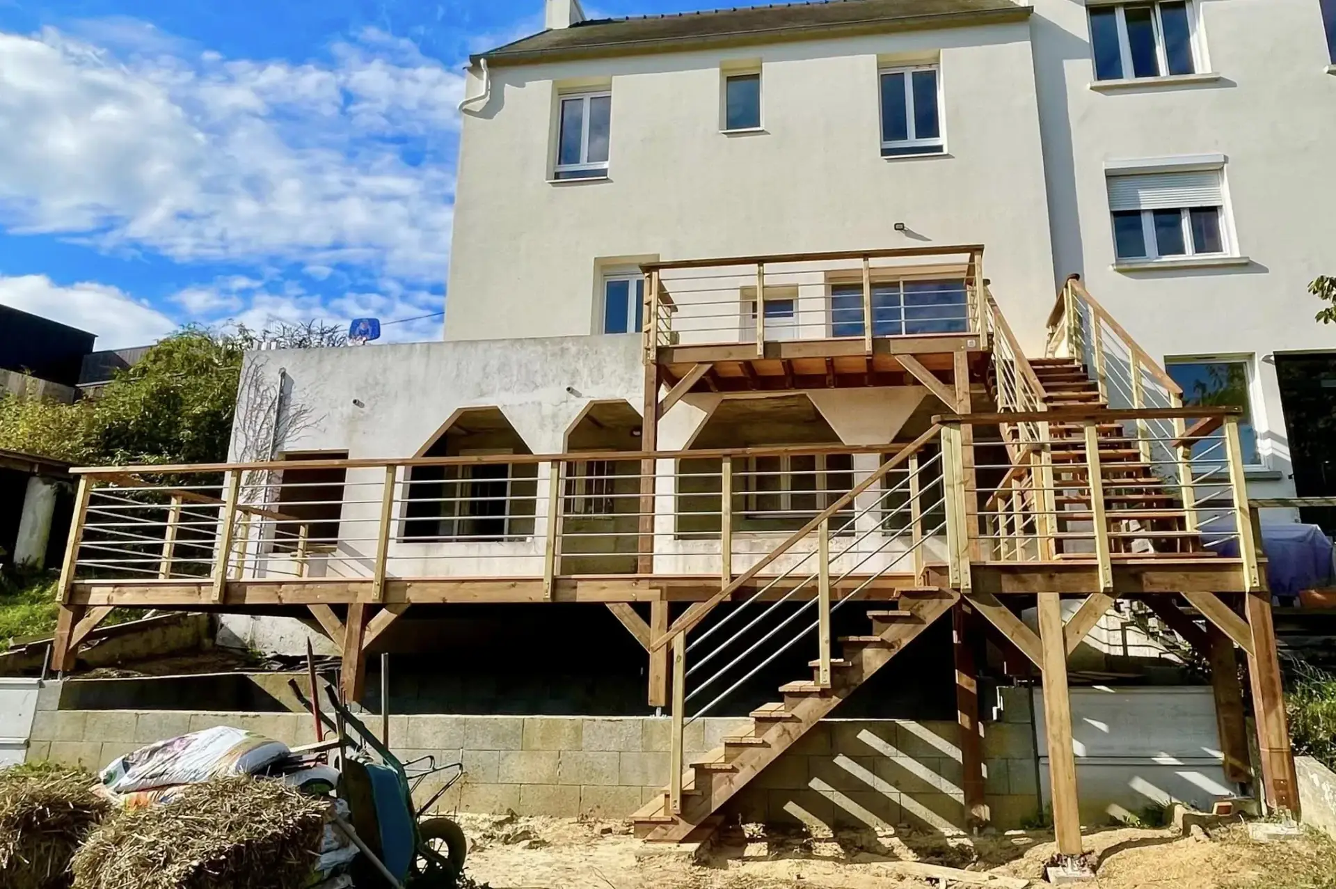 Double escalier en bois d'une terrasse sur pilotis